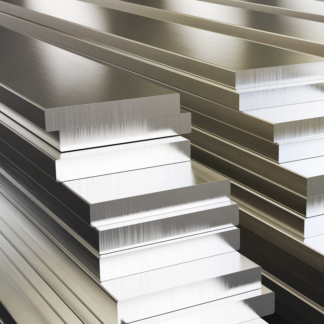 Gestapelte Aluminiumbarren liegen auf dem Boden.
